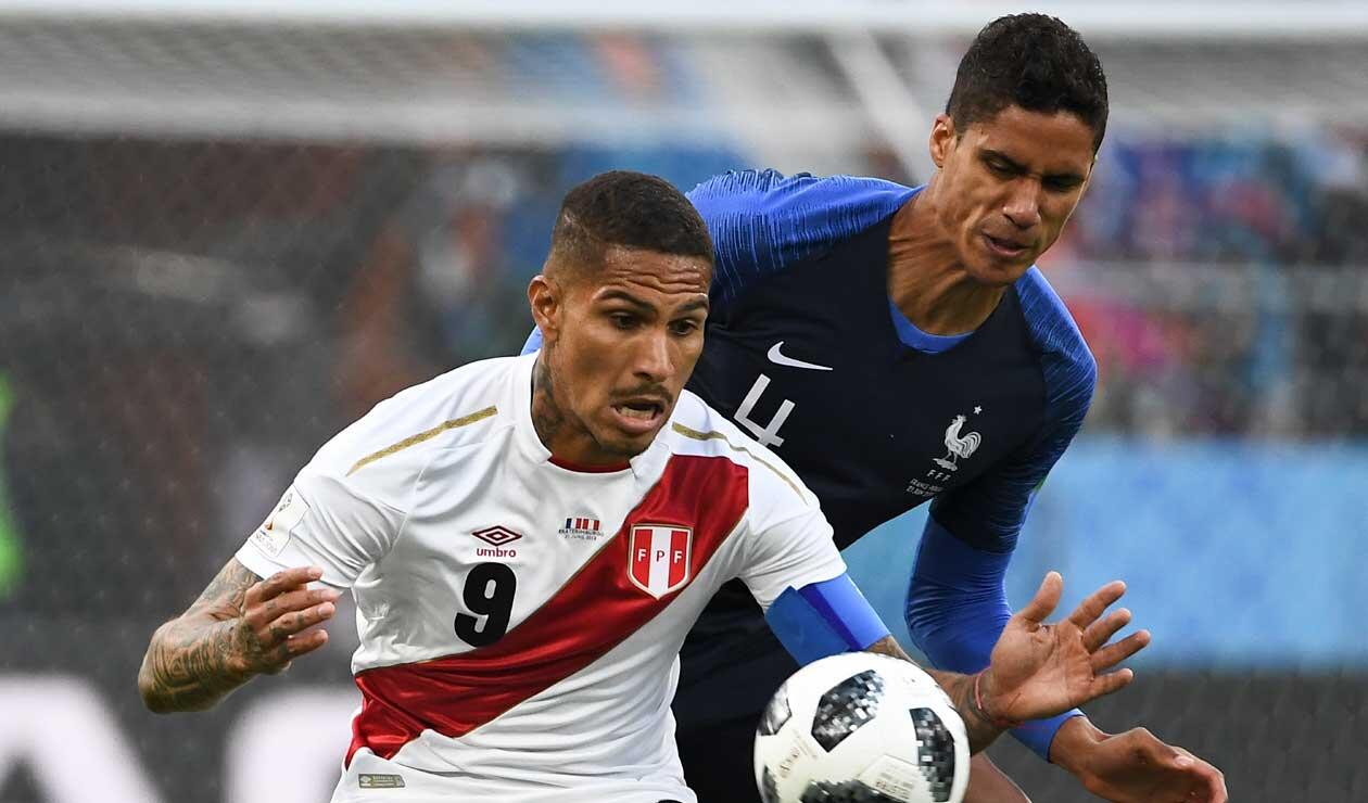 El peruano Paolo Guerrero defiende el balón ante el acoso del francés Raphael Varane 