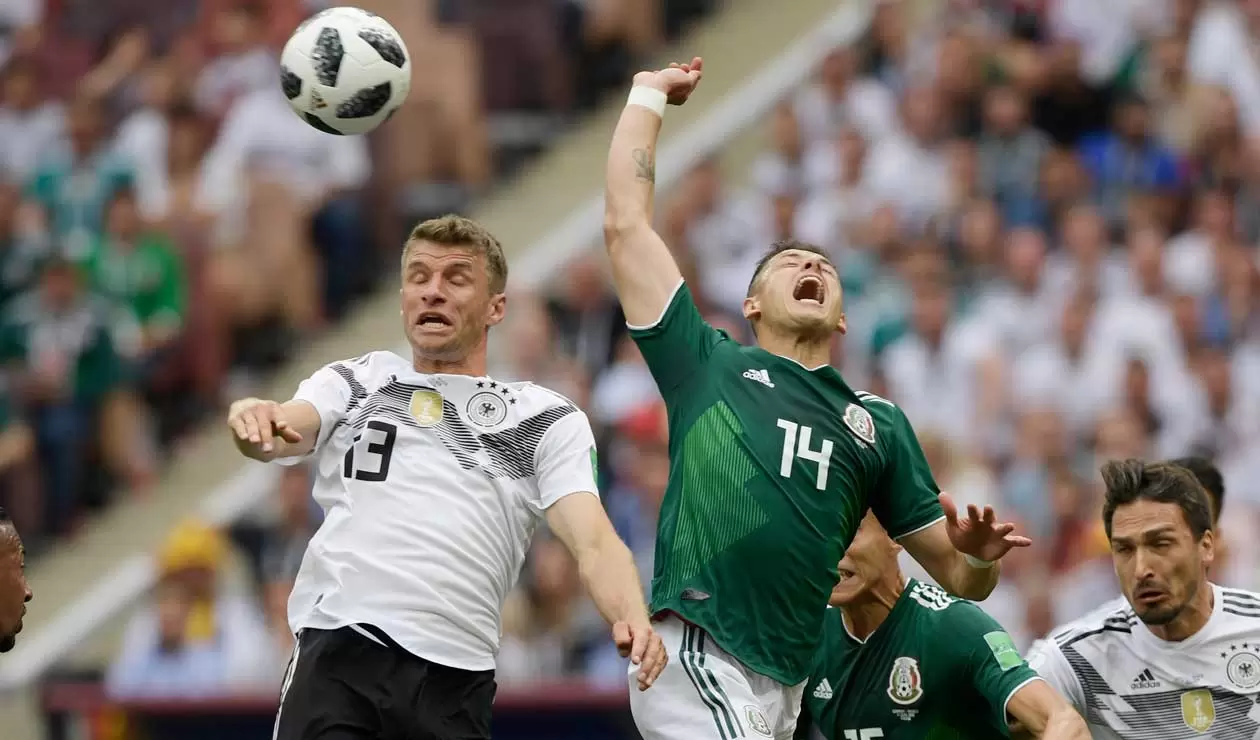 El alemán Thomas Müller disputa un balón con Javier Hernández de México