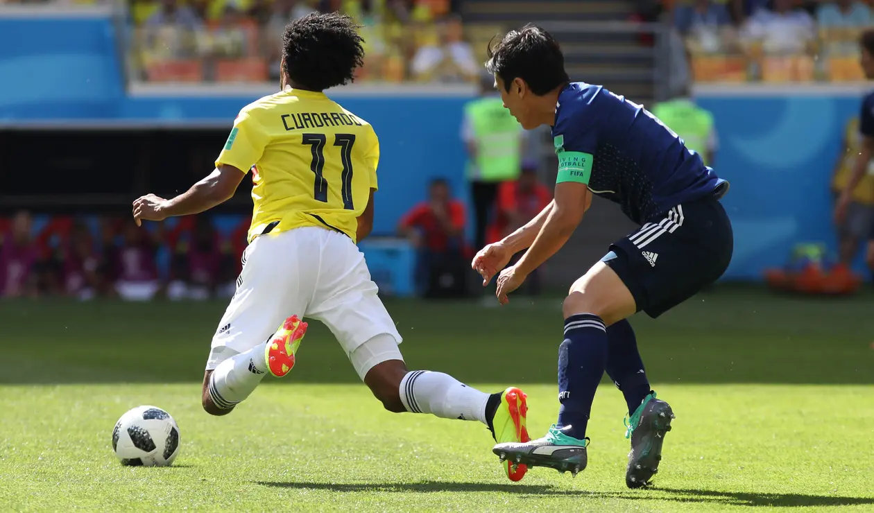 Cuadrado recibiendo una falta de un futbolista japonés
