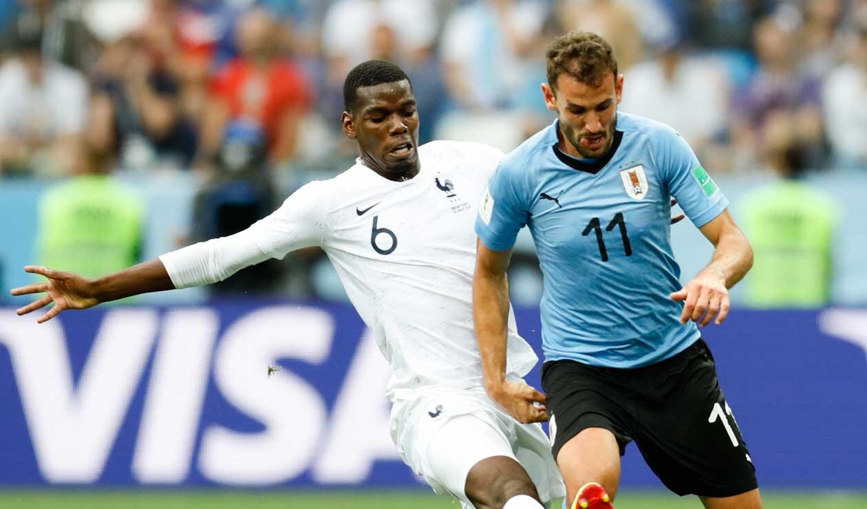 Paul Pogba disputa el balón con Stuani de Uruguay