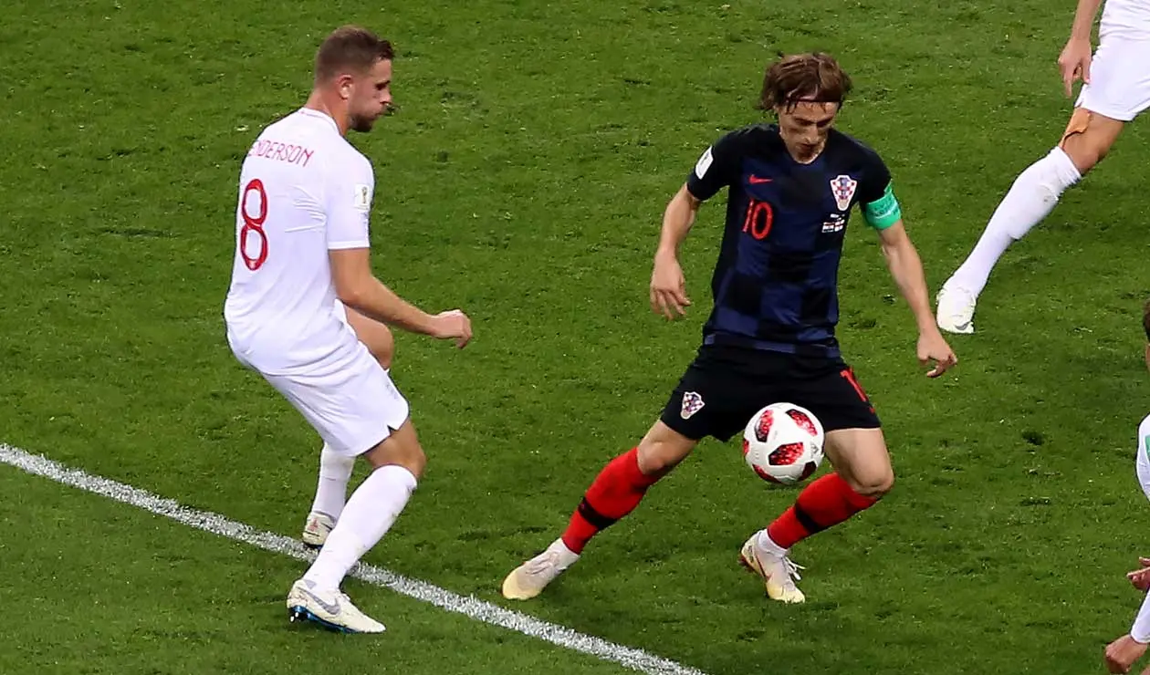 Luca Modric maneja la pelota ante la mirada de Ante Rebic