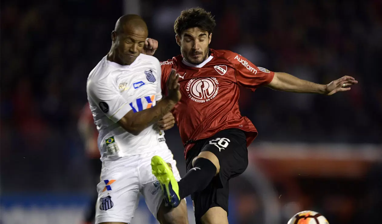 Carlos Sánchez del Santos disputa el balón con un jugador de Independiente