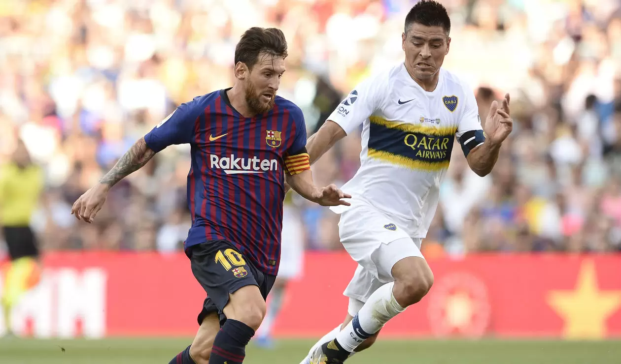 Lionel Messi del Barcelona disputa un balón con Paolo Goltz de Boca Juniors