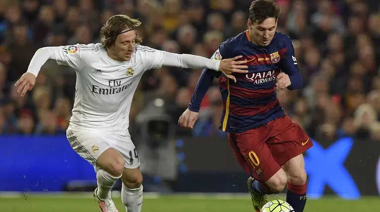 Luka Modrić y Lionel Messi disputan una pelota 