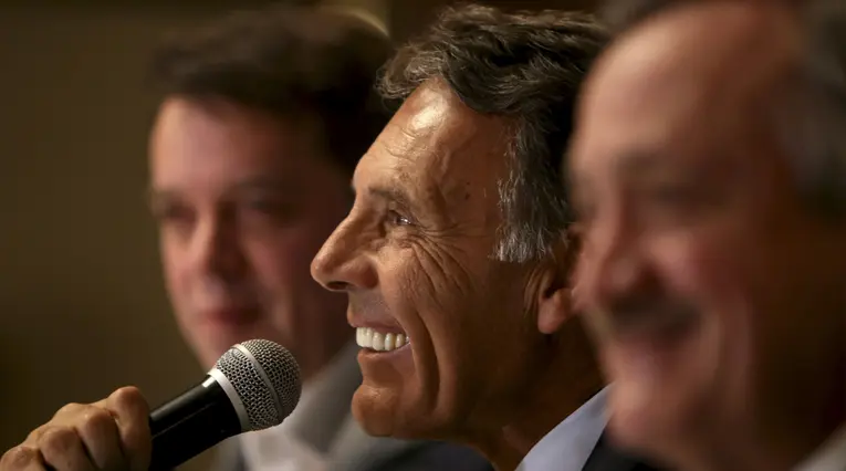 Miguel Russo en medio de Gustavo Serpa, máximo accionista, y Enrique Camacho, presidente de Millonarios