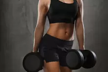 Una mujer levantando peso - Hacer ejercicio