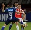Diego Güastavino (Santa Fe) ante la marca de dos jugadores de Millonarios